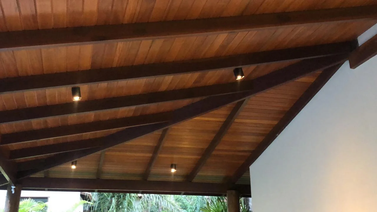 Forro de madeira com vigas aparentes e pequenos pontos de iluminação.