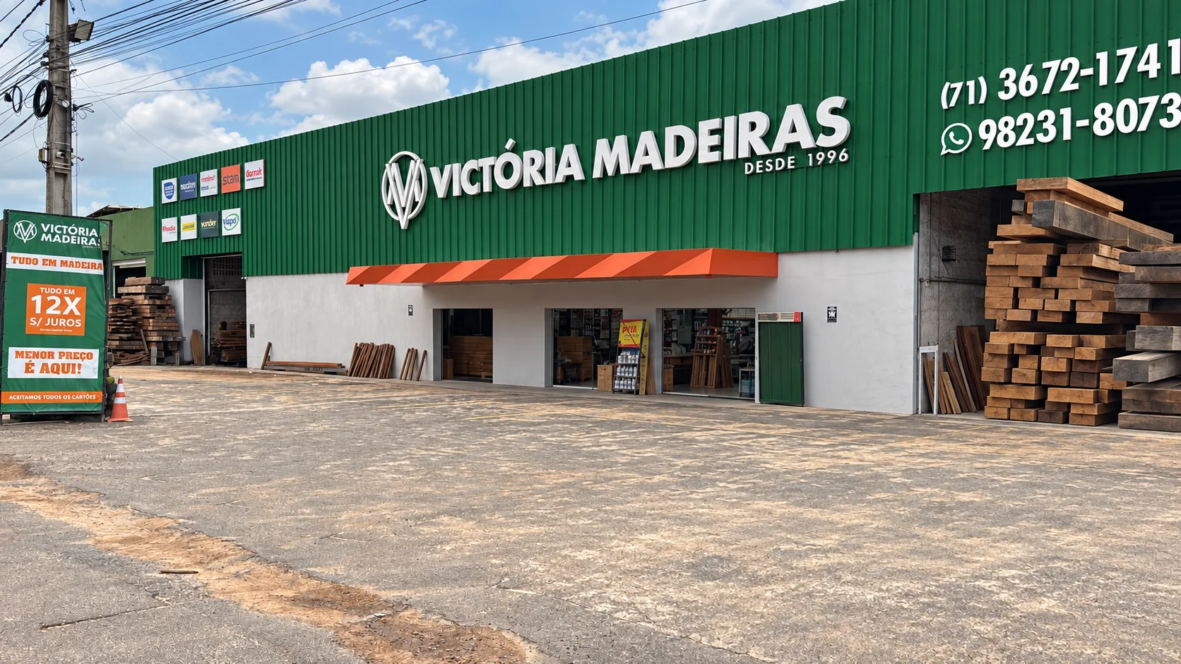 Fachada da Victória Madeiras em Jauá, com o monograma e o nome da loja sobre o revestimento verde.